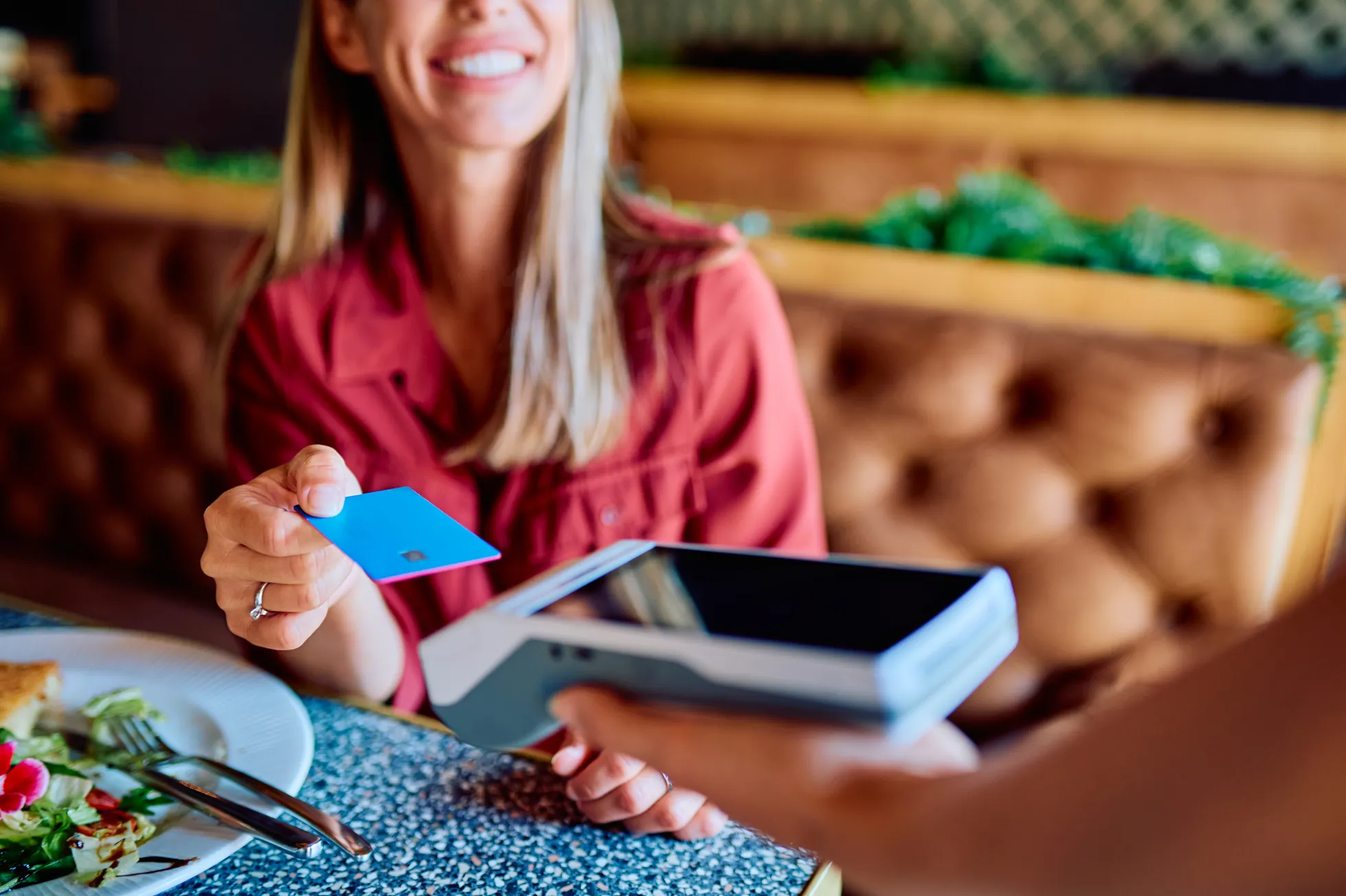 Woman making a secure wireless transaction using a credit card Woman making a secure wireless transaction using a credit card