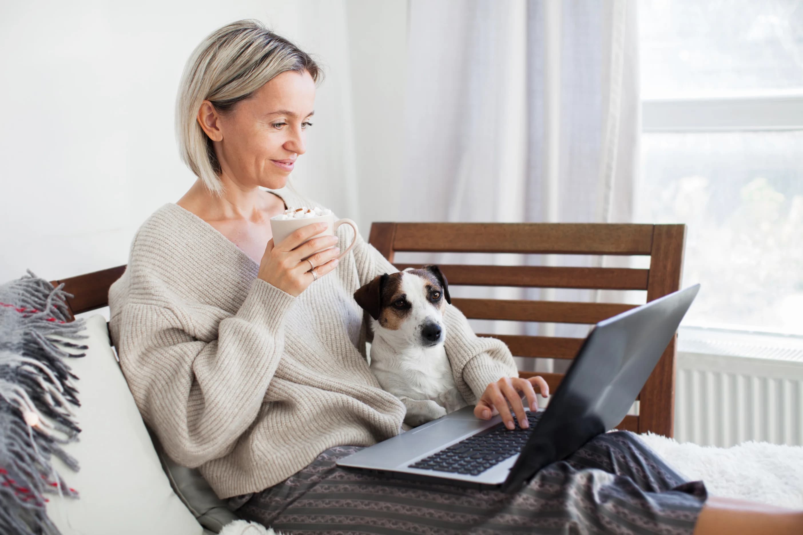 Middle aged woman using her laptop on the sofa at home