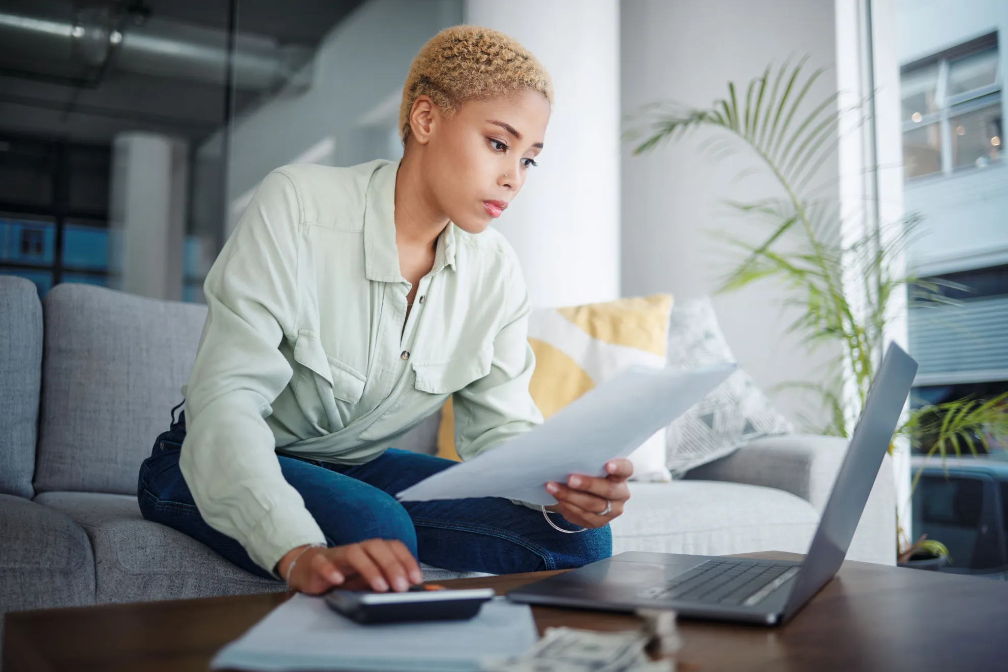 person-at-desk-with-calculator-reviewing-multiple-credit-card-statements-and-loan-documents