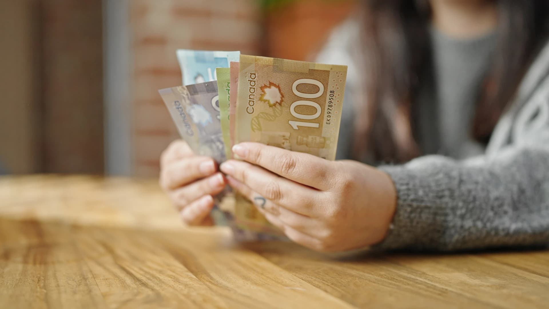 Woman counting canadian dollars Woman counting canadian dollars