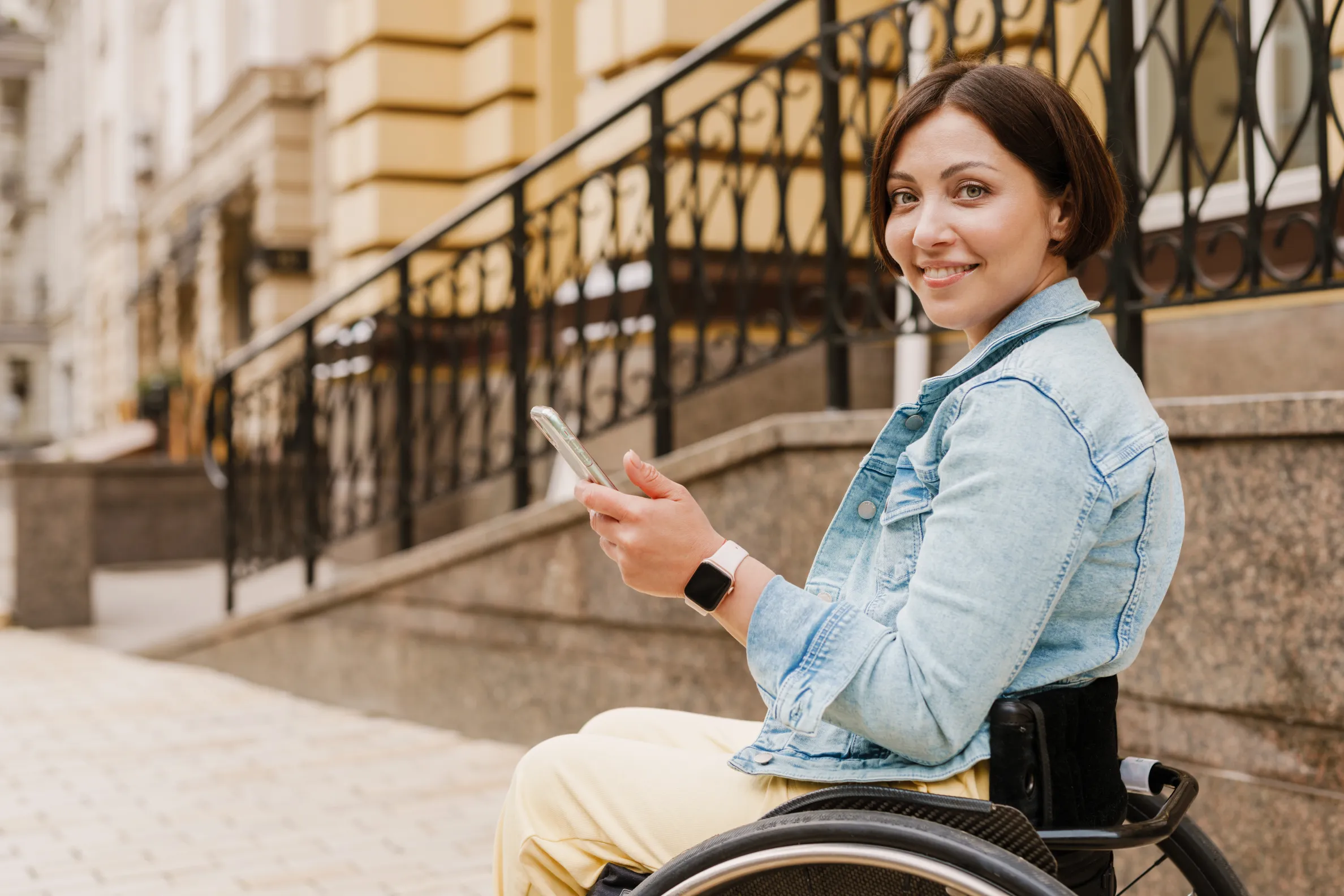 Woman using mobile phone while sitting in wheelchair