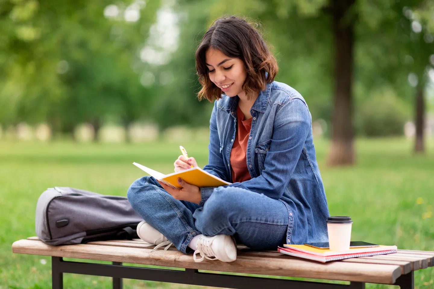 canadian-student-calculating-expenses-with-smartphone-and-coffee
