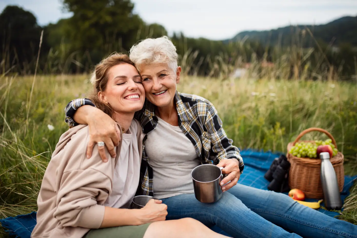 mother-and-daughter-smiling-together-while-enjoying-a-picnic-in-a-park-surrounded-by-spring-flowers