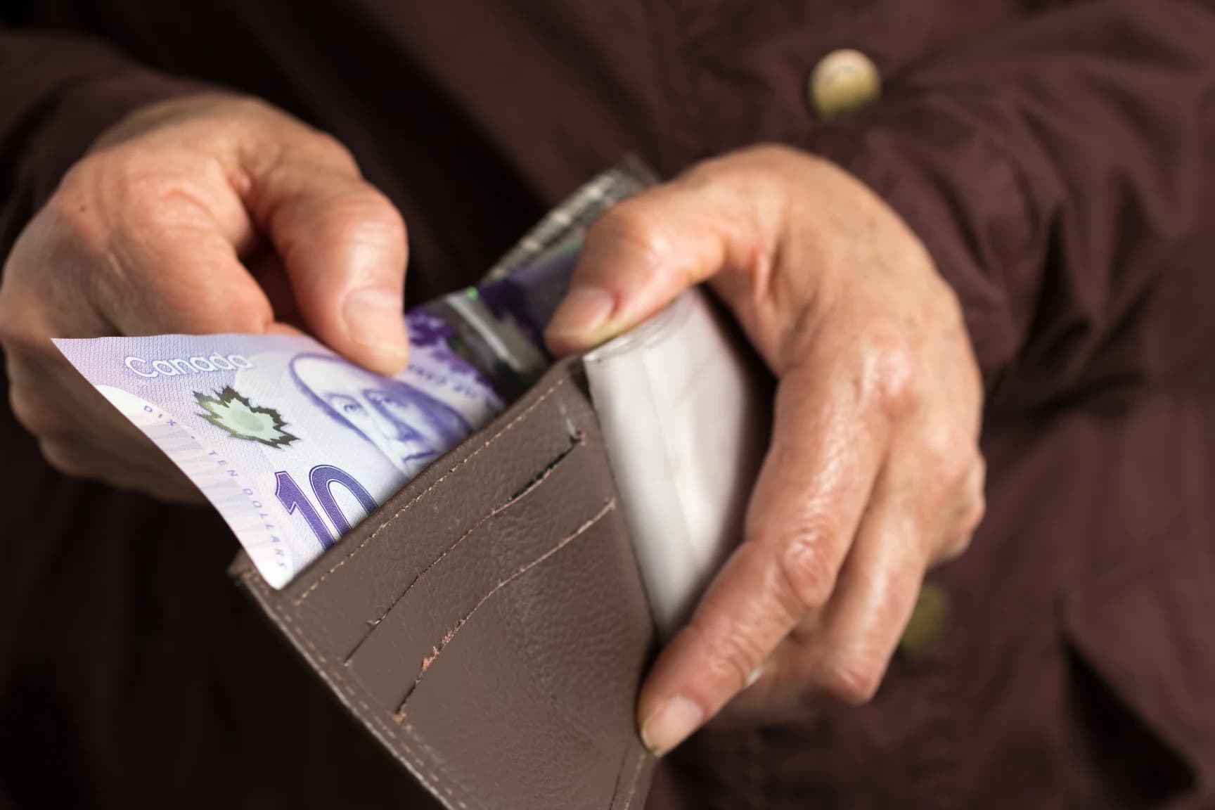 close-up-of-hands-holding-cash-to-cover-emergency-expenses