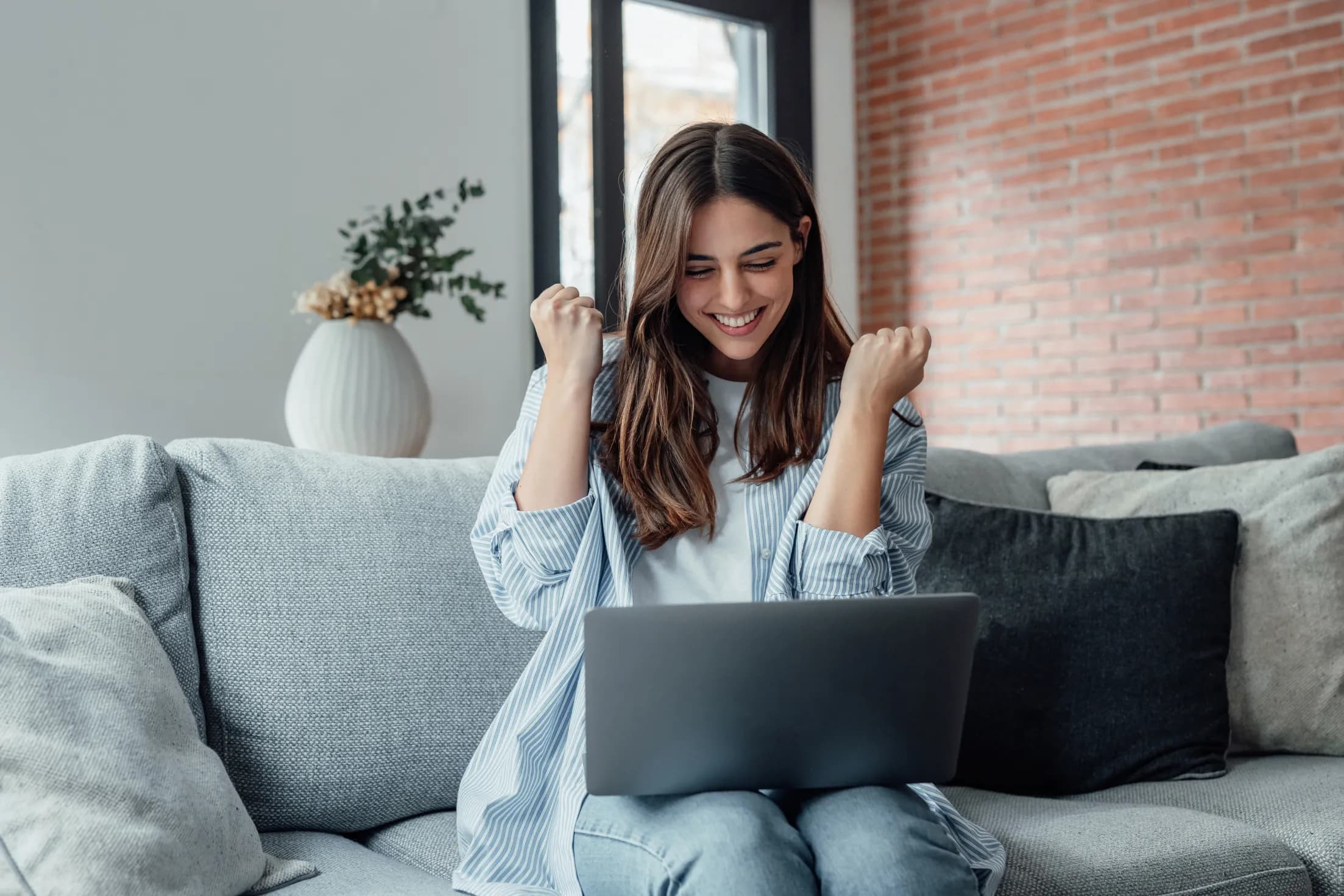 Excited woman holding a laptop on her lap